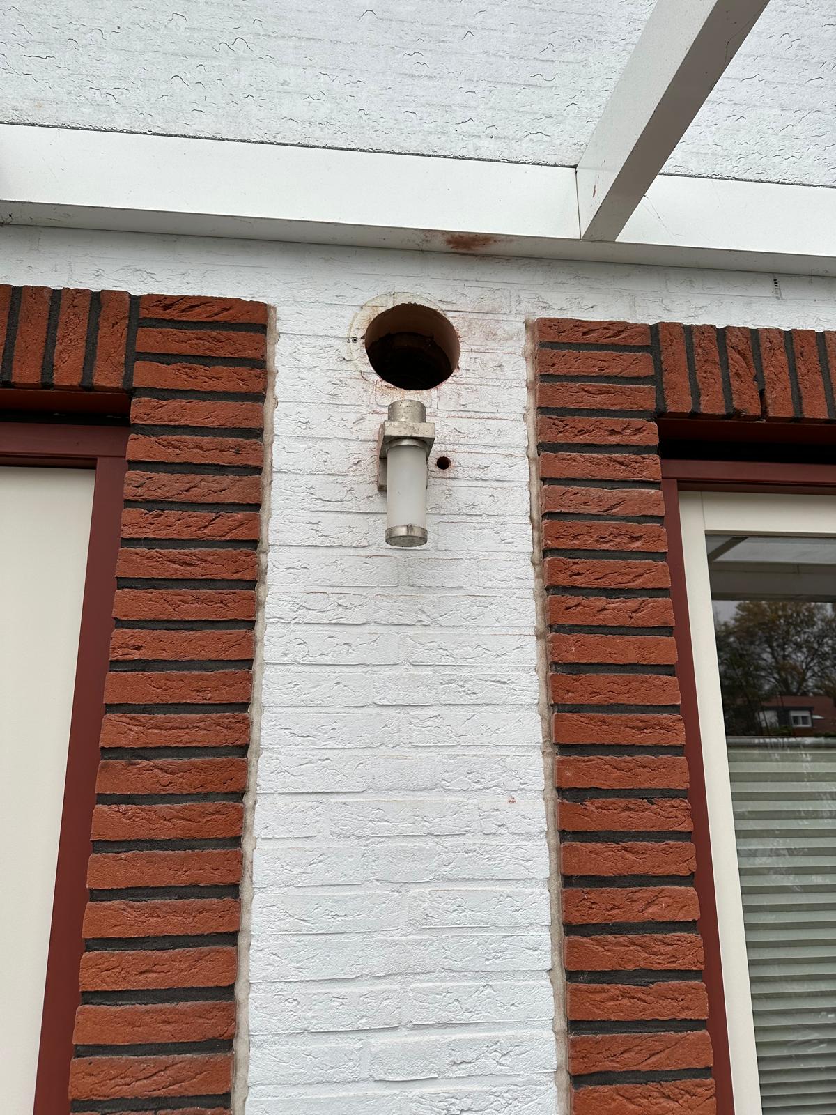 Afzuigkap boring in witte bakstenen pilaar