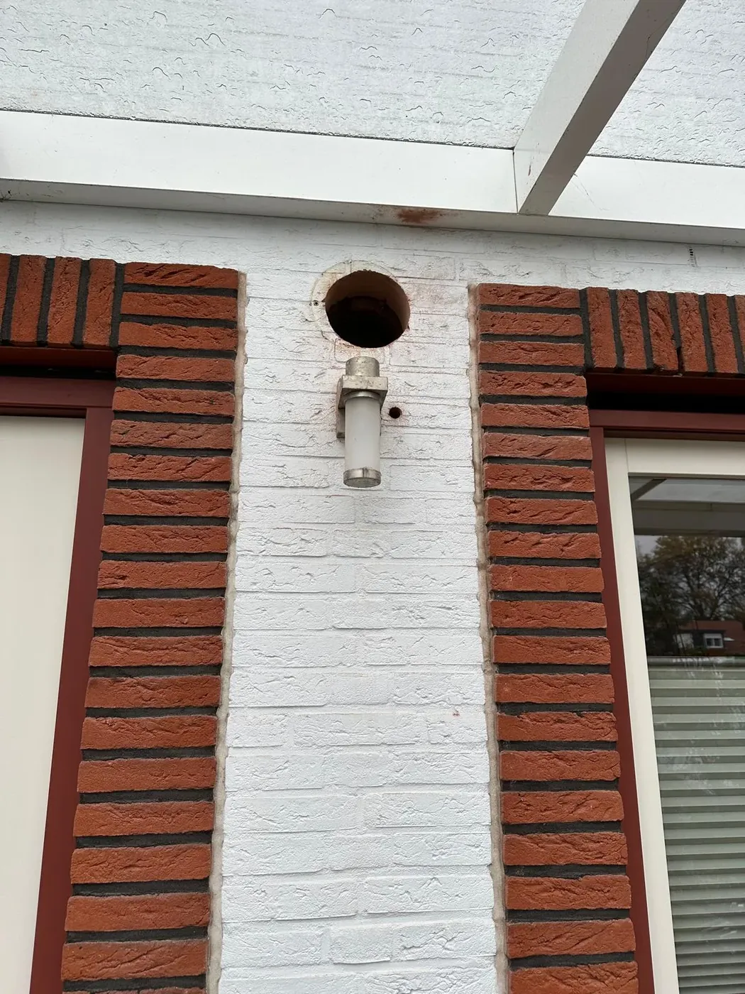 Afzuigkap boring in witte bakstenen pilaar