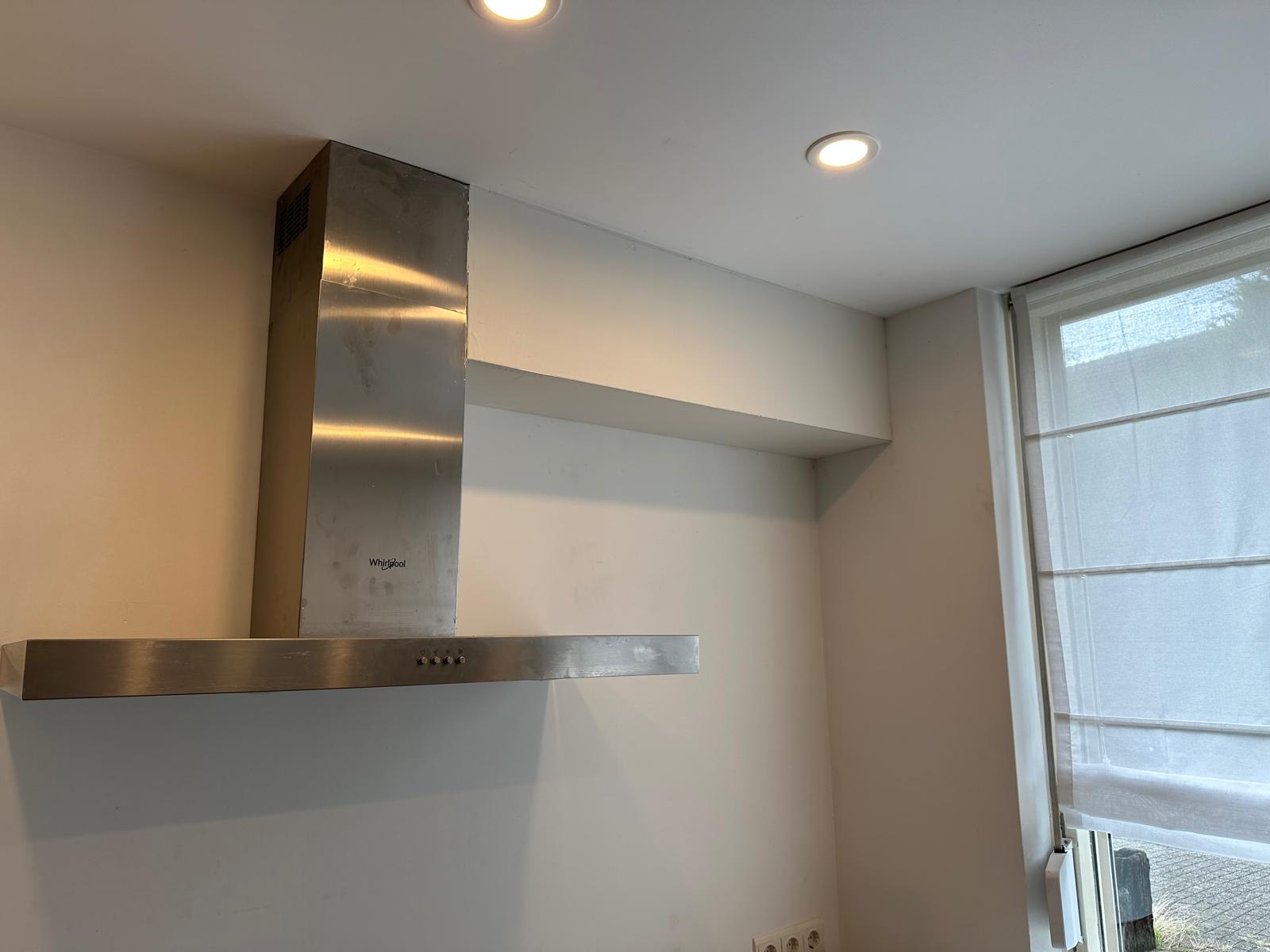Whirlpool RVS afzuigkap met witte koof plank afgewerkt