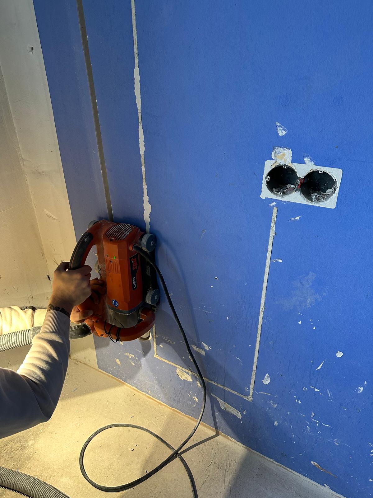 Sleuven frezen machine in blauwe muur