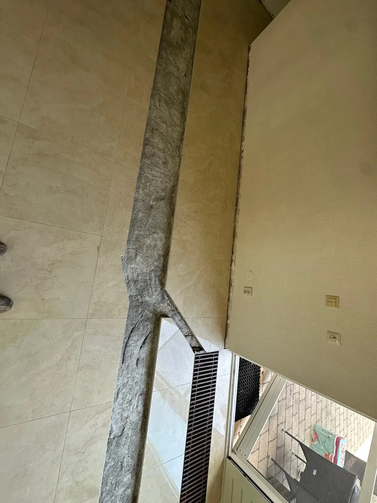 Close-up sleuf gezaagd in tegelvloer naast wand — nauwkeurig zaagwerk