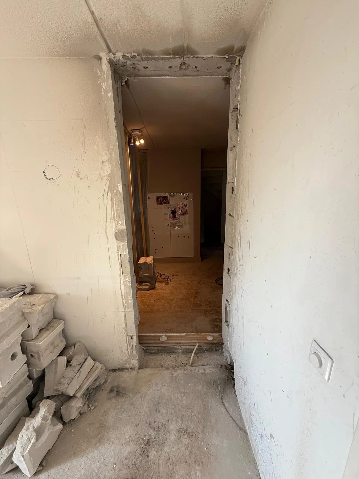 Nieuwe deuropening gemaakt in binnenwand — muur doorgebroken, puin opzij
