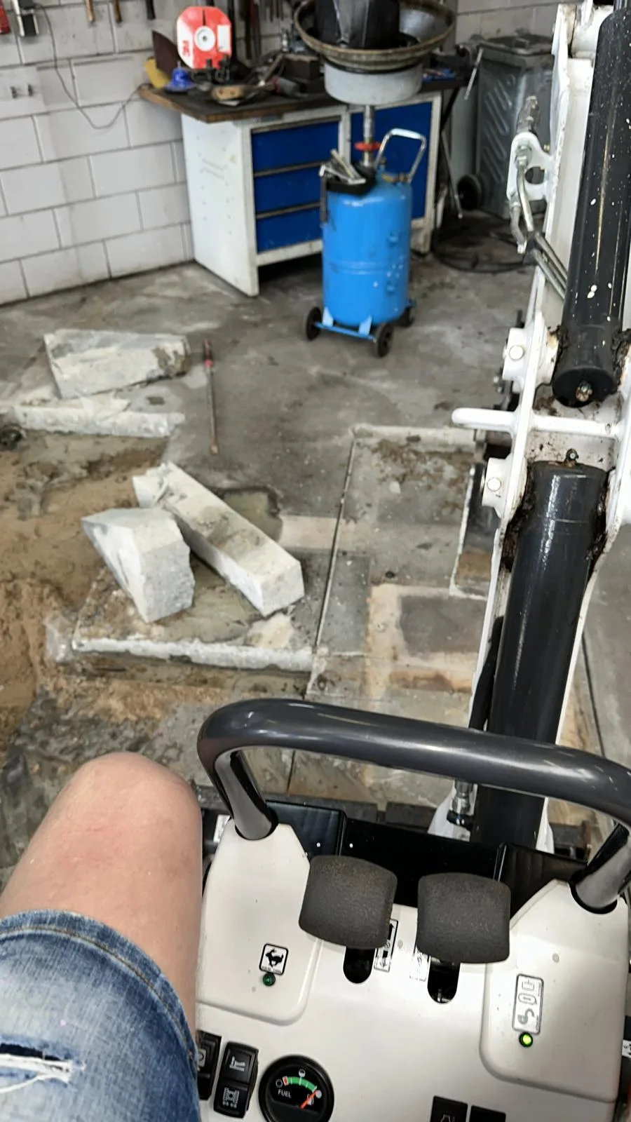 Minigraver cockpit — betonvloer stukken verwijderd in werkplaats garage